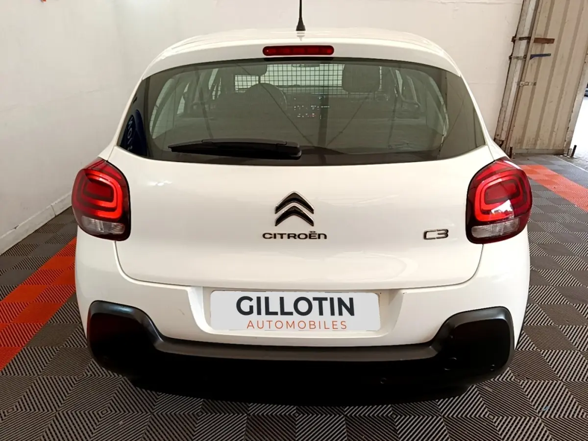 Vue arrière d'une Citroën C3 blanche 2021 avec feux arrière LED et pare-chocs noir dans un garage.