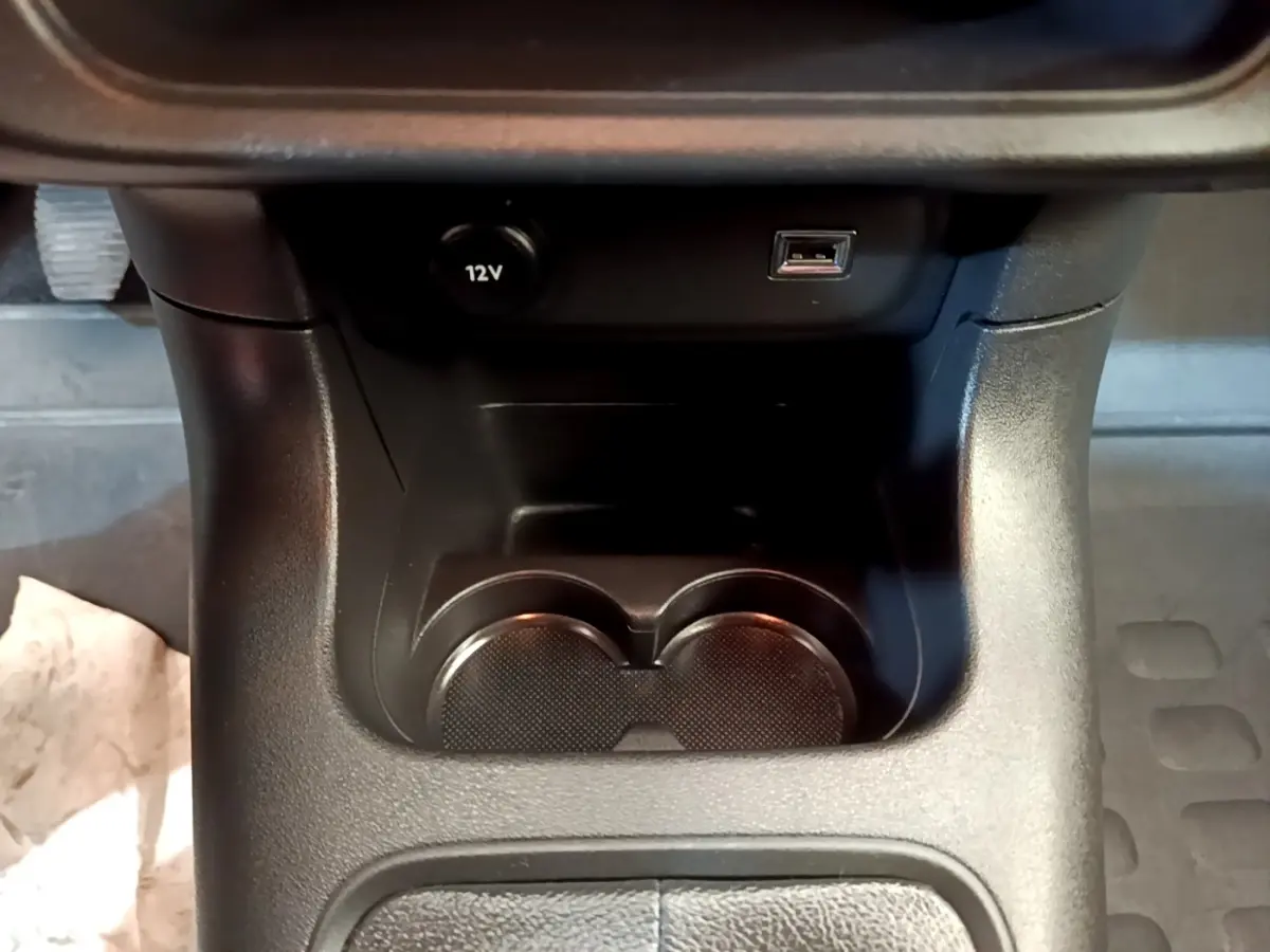 Gros plan sur la console centrale noire avec prise 12V et port USB du Citroën C3 blanc, version 2021.