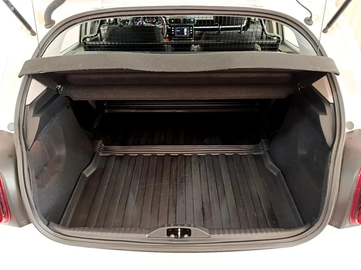 Vue arrière du coffre ouvert d'une Citroën C3 blanche, montrant l'espace de chargement et la grille de séparation intérieure.