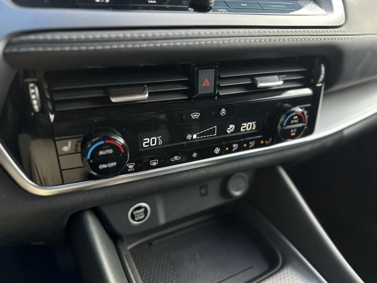 Détail de la console centrale du Nissan Qashqai 2025, affichage digital de la climatisation bi-zone et bouton Start/Stop.