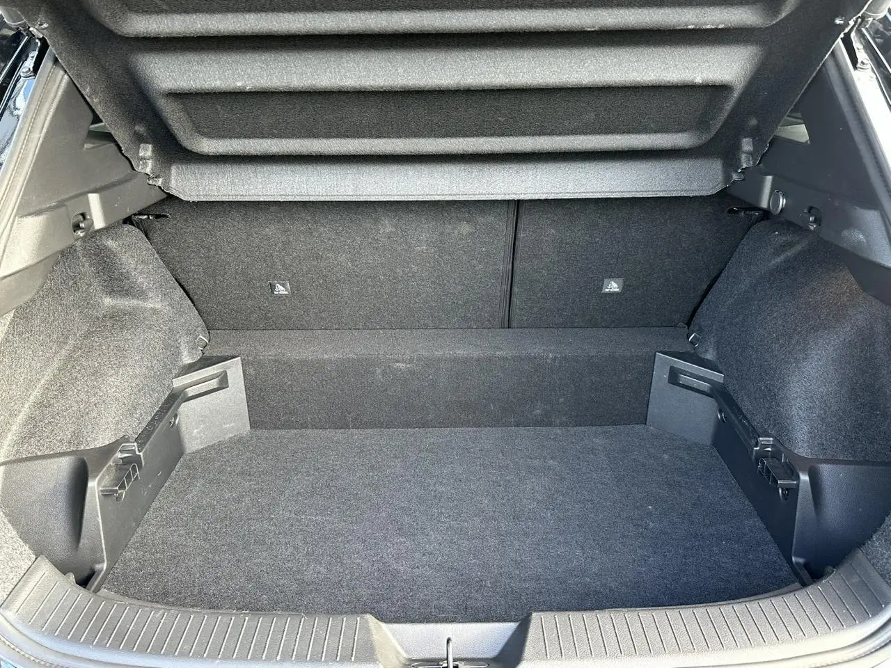 Coffre ouvert du Nissan Qashqai blanc nacré, vue arrière avec hayon électrique et plancher modulable.