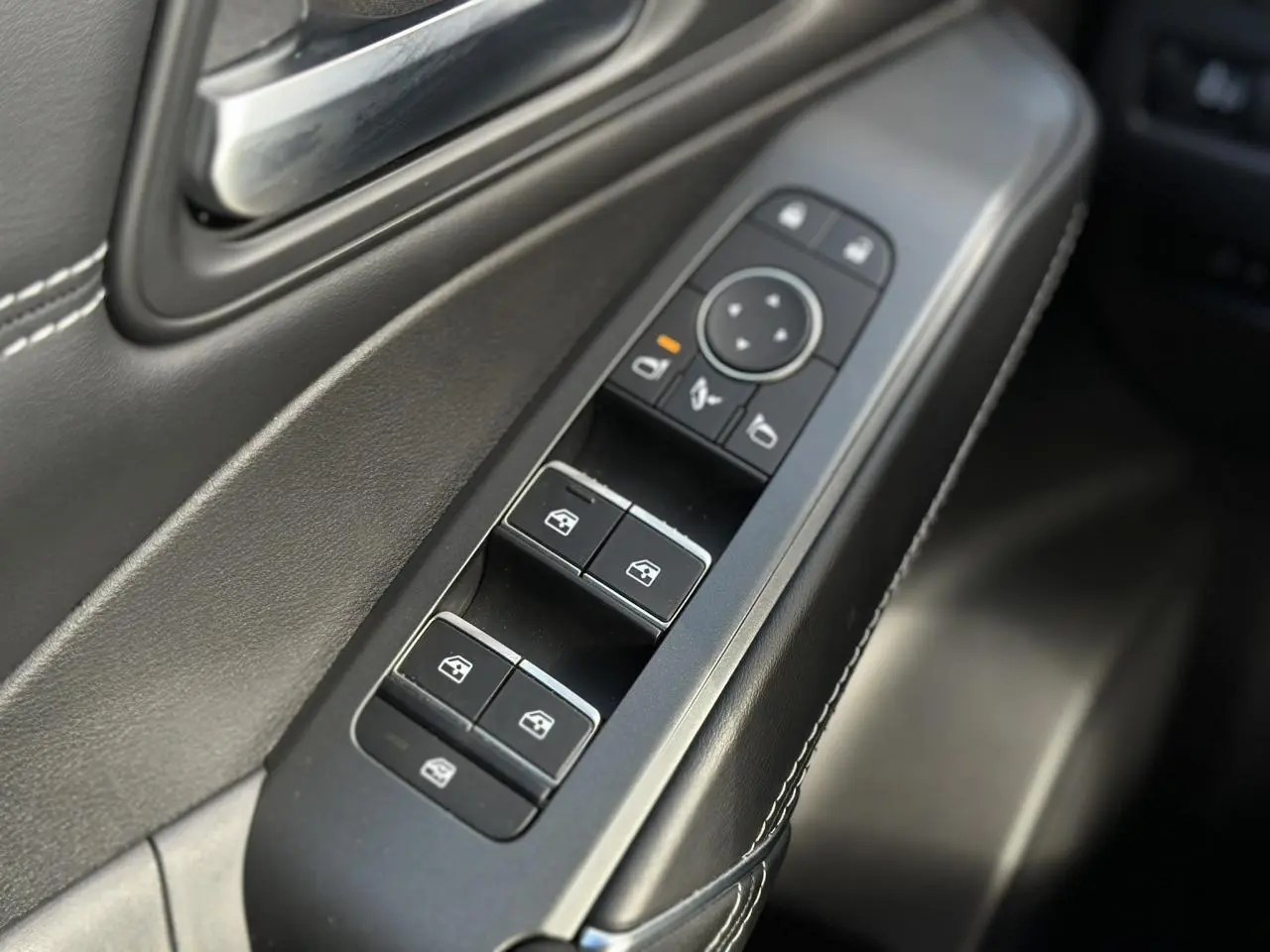 Gros plan sur les commandes des vitres électriques et rétroviseurs sur la porte côté conducteur du Nissan Qashqai 2025.