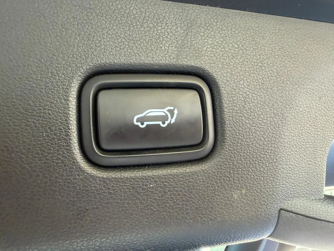 Bouton noir de commande d'ouverture du hayon sur tableau de bord intérieur du Hyundai Tucson noir 2022.