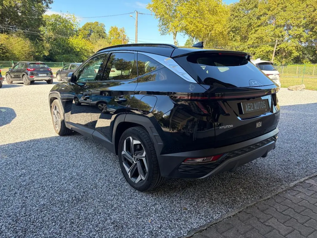 Vue 3/4 arrière droite du Hyundai Tucson noir 2022 avec barres de toit et feux arrière LED distinctifs.