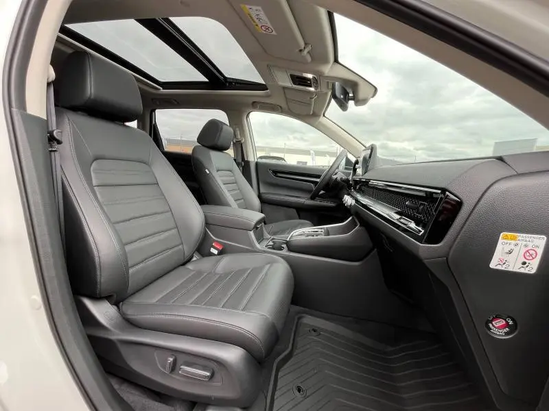 Intérieur avant du Honda CR-V blanc nacré 2024, sièges cuir noirs, toit panoramique et tableau de bord moderne.