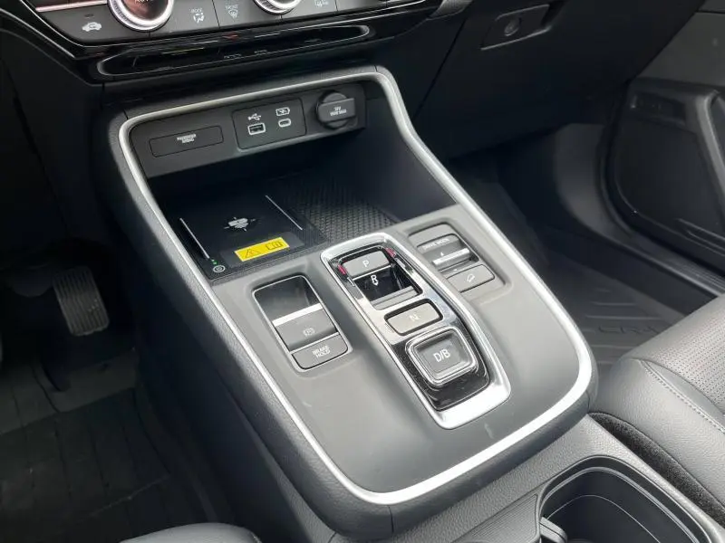 Gros plan sur la console centrale noire du Honda CR-V 2024 avec commandes de boîte automatique et prises USB visibles.