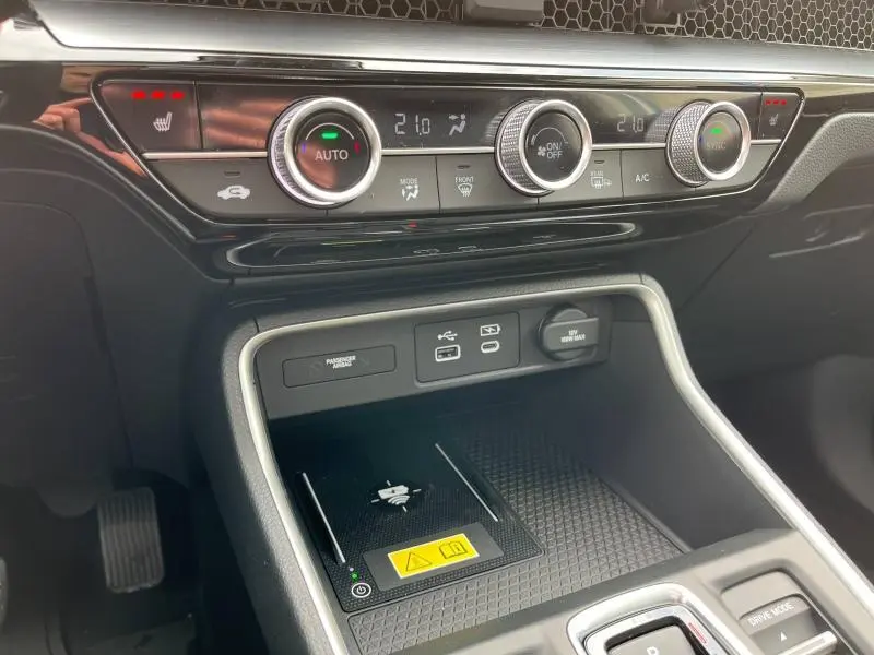 Détail de la console centrale noire du Honda CR-V 2024 avec commandes climatisation et chargeur sans fil.