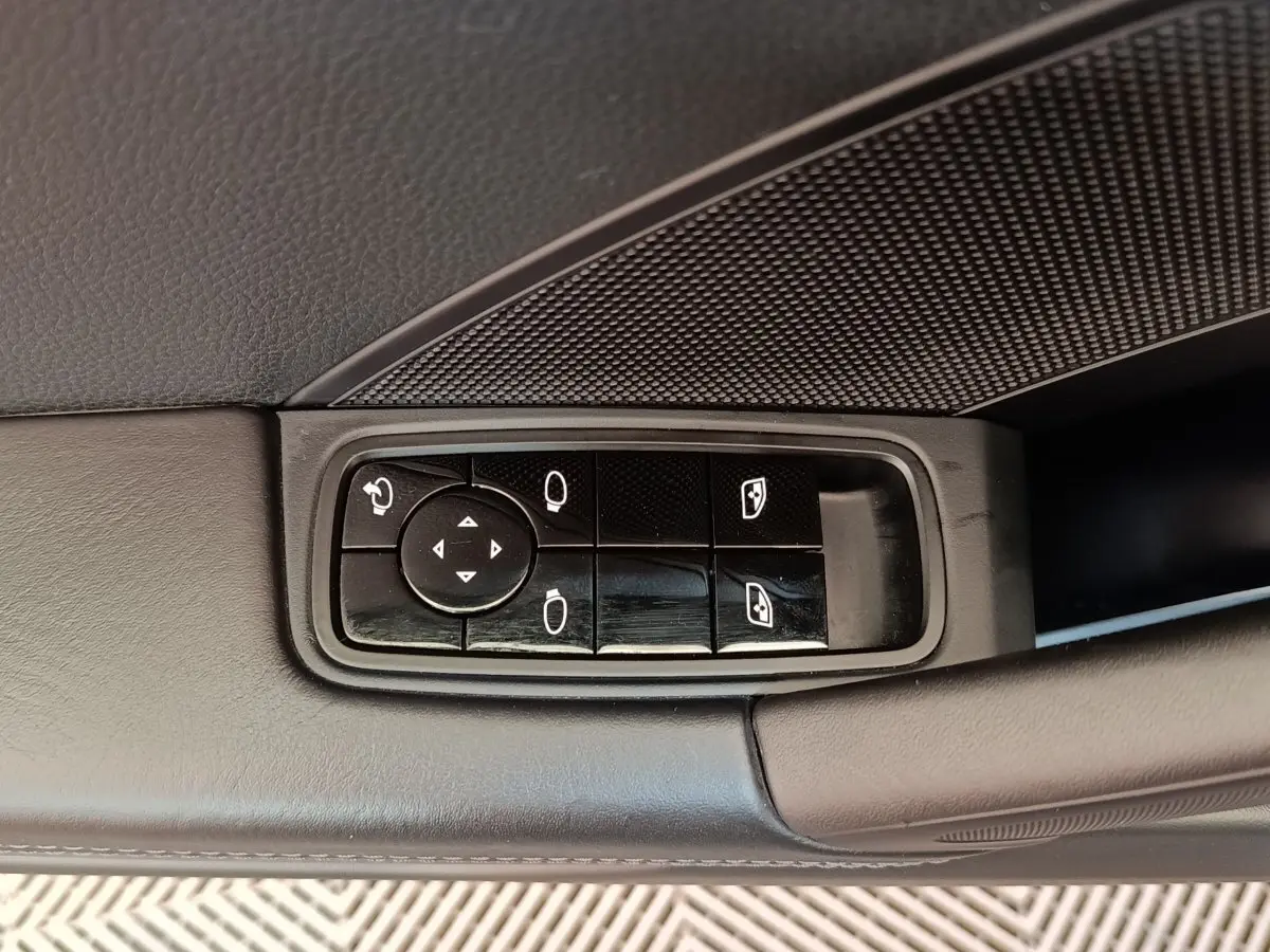 Gros plan sur les commandes de réglage des rétroviseurs et vitres côté gauche d'une Porsche 911 Carrera 4S Coupé gris foncé de 2019.