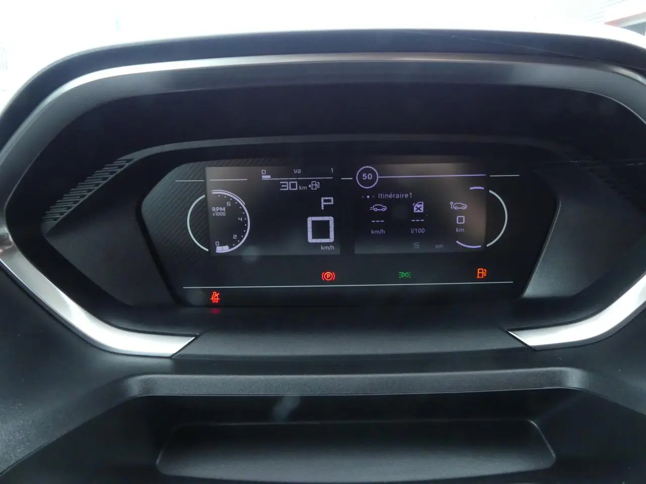 Affichage numérique du tableau de bord du Peugeot Partner blanc 2025, montrant la vitesse à 0 km/h et indicateurs allumés.