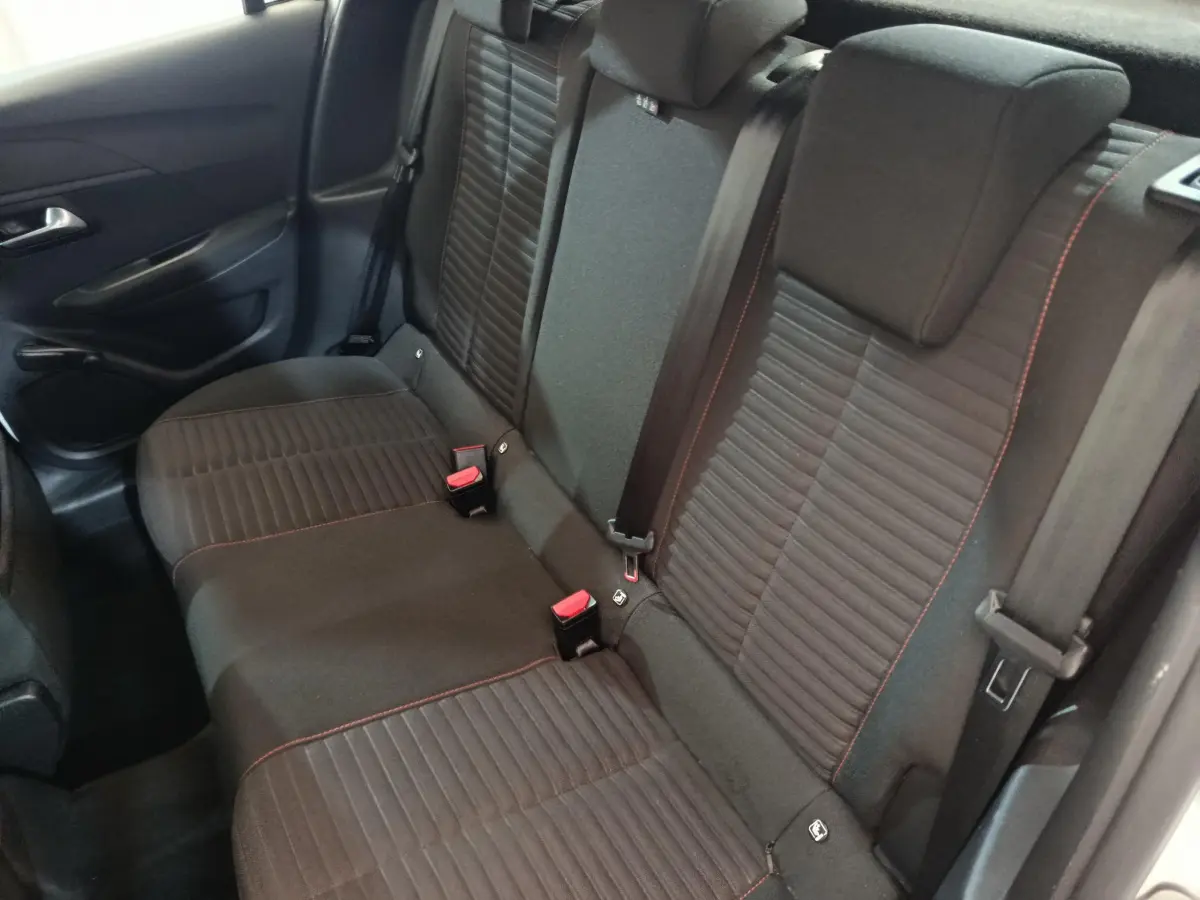 Vue intérieure côté gauche de la banquette arrière noire avec surpiqûres rouges d'une Peugeot 208 blanche 2020.