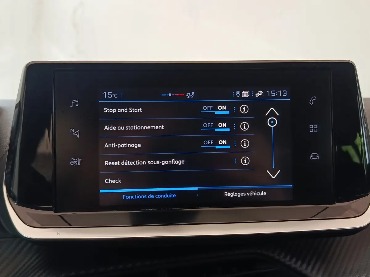 Écran tactile central de la Peugeot 208 PureTech 100 blanc affichant les réglages d'aide à la conduite.