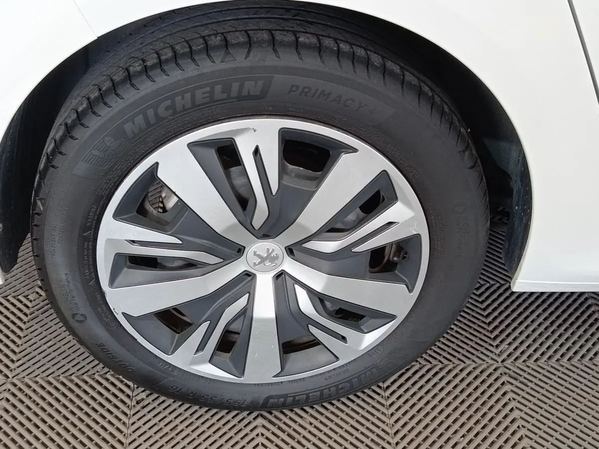 Gros plan sur la roue avant droite blanche d'une Peugeot 208 PureTech 100 S&S Active Business avec jante spécifique.