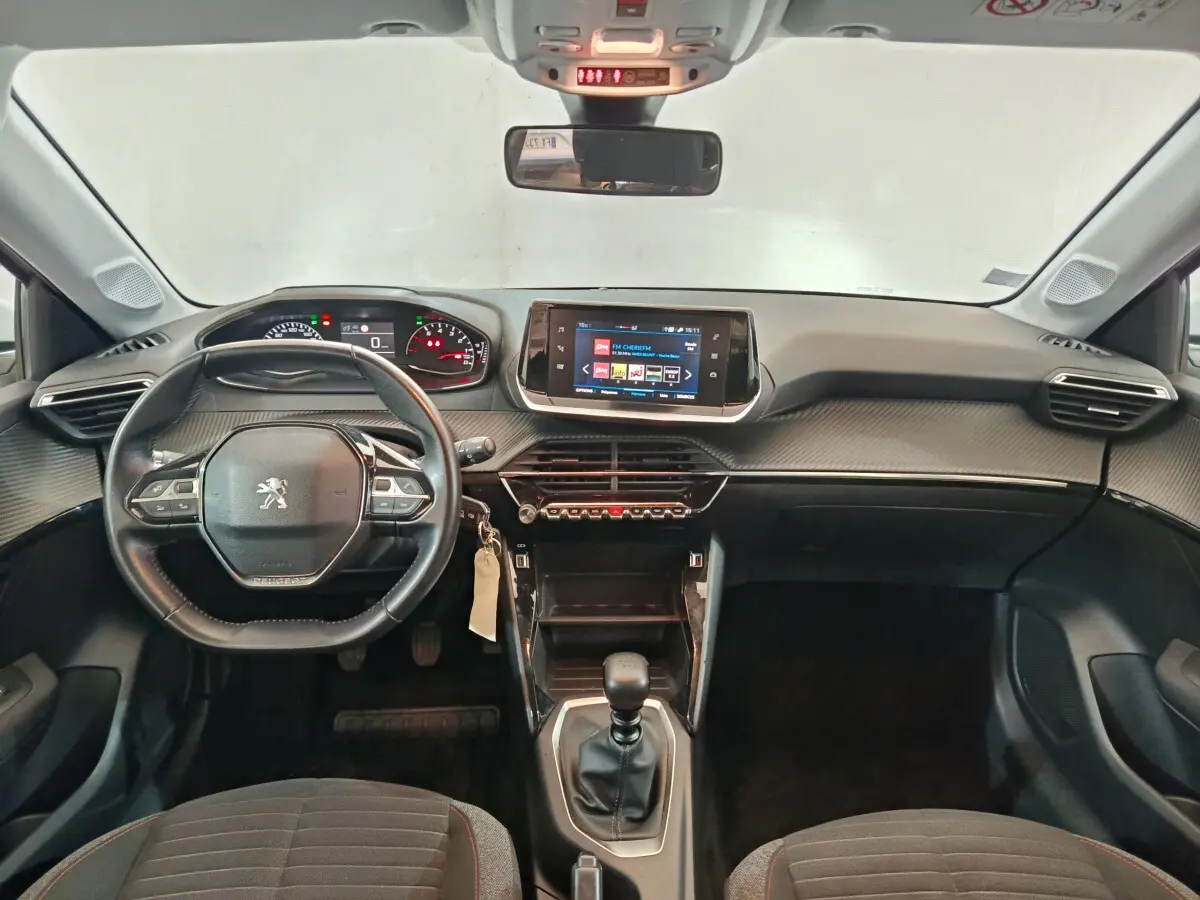 Vue intérieure avant du tableau de bord et volant cuir noir de la Peugeot 208 PureTech 100 S&S Active Business 2020.