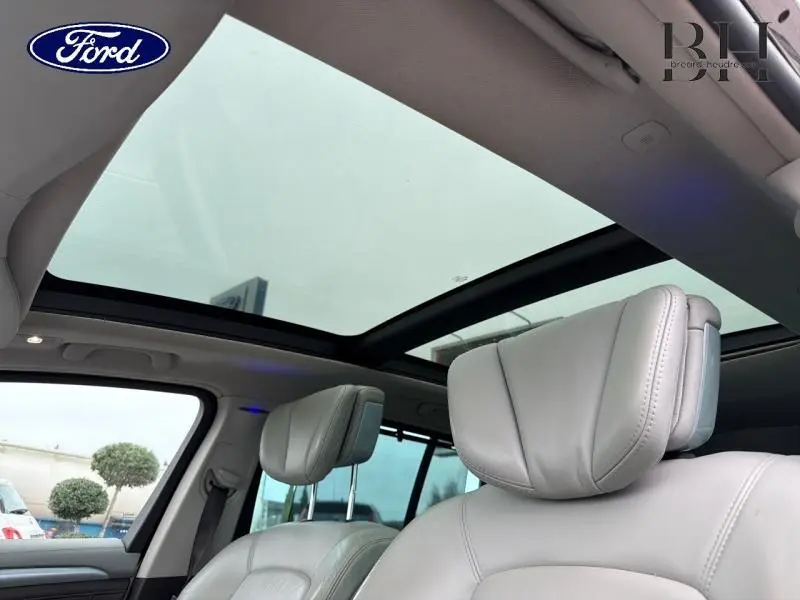 Vue intérieure du Renault Espace blanc Glacier 2015, montrant les sièges avant en cuir et le toit panoramique vitré.