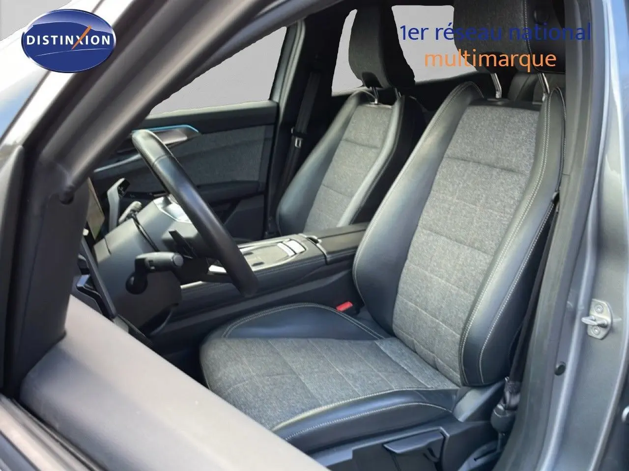 Vue intérieure côté conducteur du Renault Espace 2024, sièges bi-matière tissu gris et cuir noir avec surpiqûres contrastées.