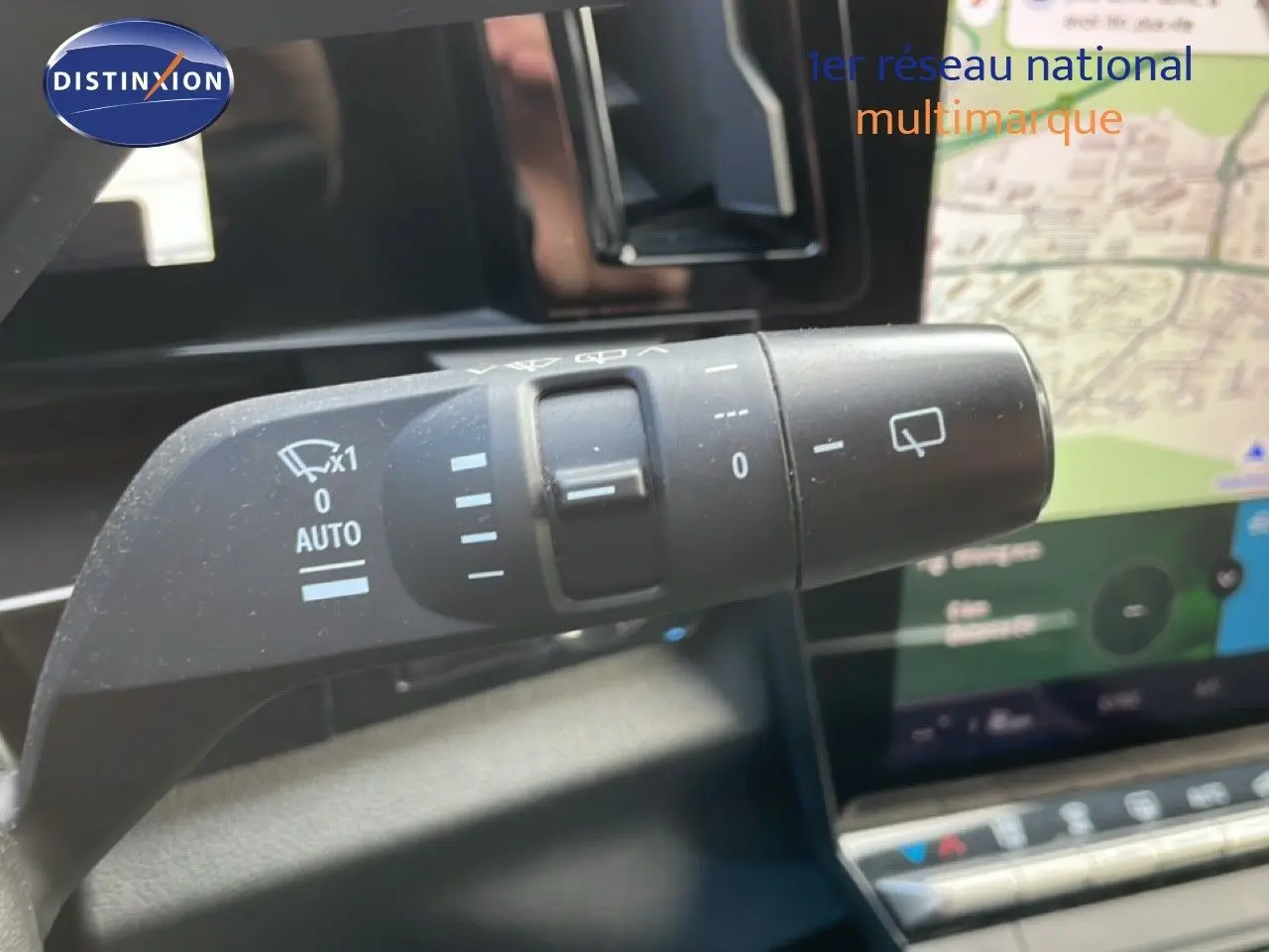 Gros plan sur la commande d’essuie-glace du Renault Espace gris, avec écran tactile et carte visible en arrière-plan.