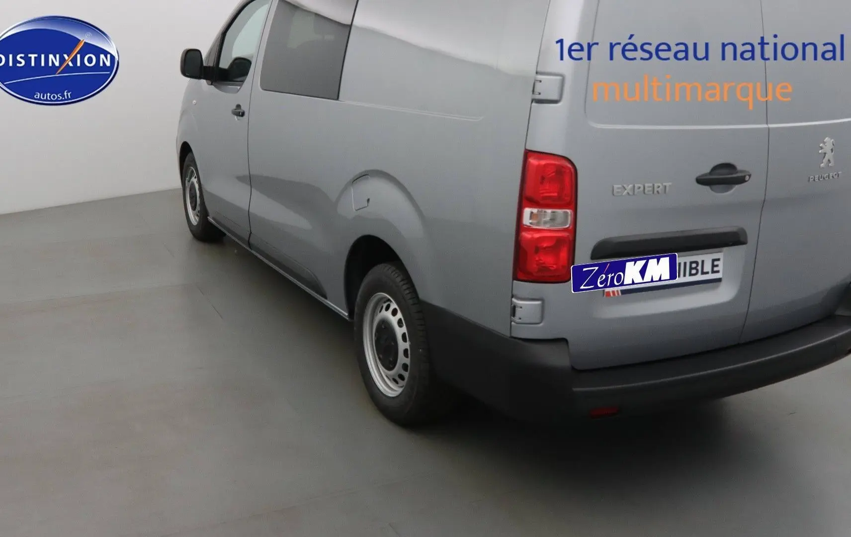 Vue 3/4 arrière droite d'un Peugeot Expert Long gris Artense métallisé avec logo et hayon fermé dans un studio.