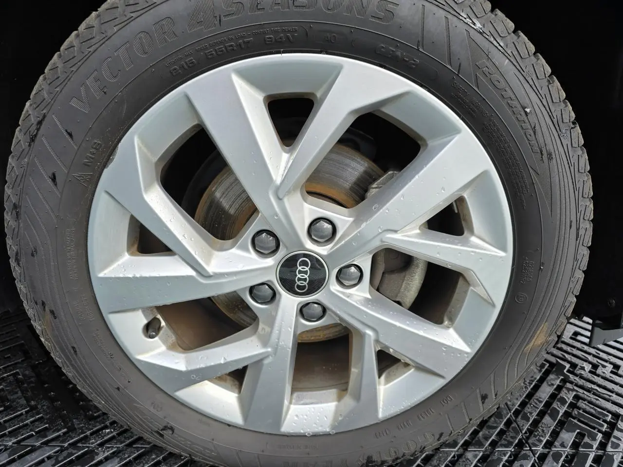 Gros plan sur la jante aluminium 5 branches doubles de l'Audi Q2 noir mythic avec pneu toutes saisons.