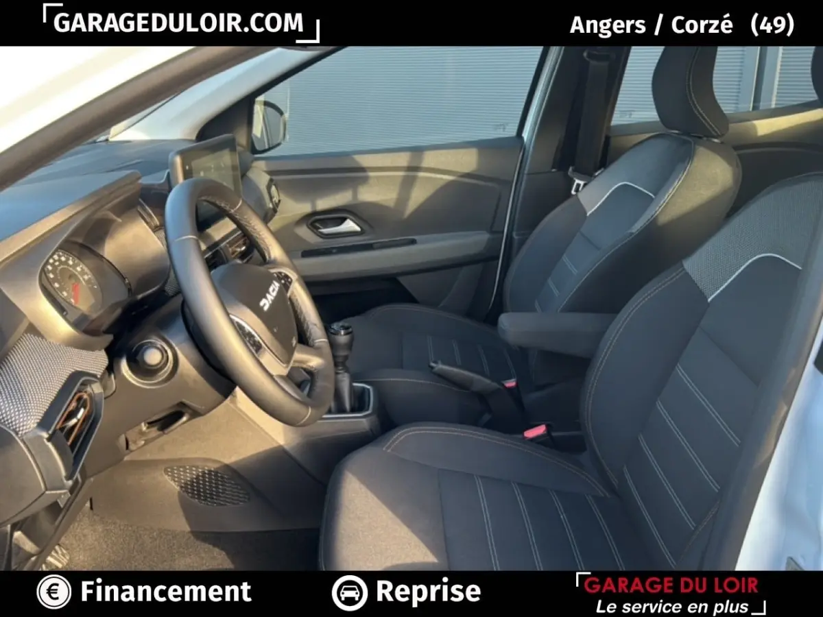 Vue intérieure côté conducteur du Dacia Sandero Expression TCe 90 2025, sièges noirs avec surpiqûres et volant multifonction.