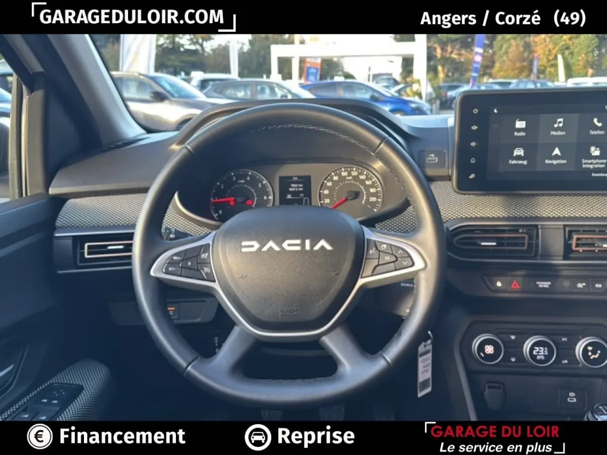 Vue intérieure centrée sur le volant noir DACIA avec tableau de bord et écran tactile du Sandero Expression TCe 90 blanc 2025.