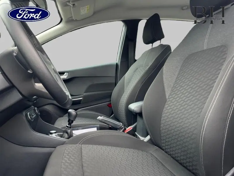 Vue intérieure côté conducteur de la Ford Fiesta 2022, sièges tissu noir Kasbah/Eton et volant cuir.