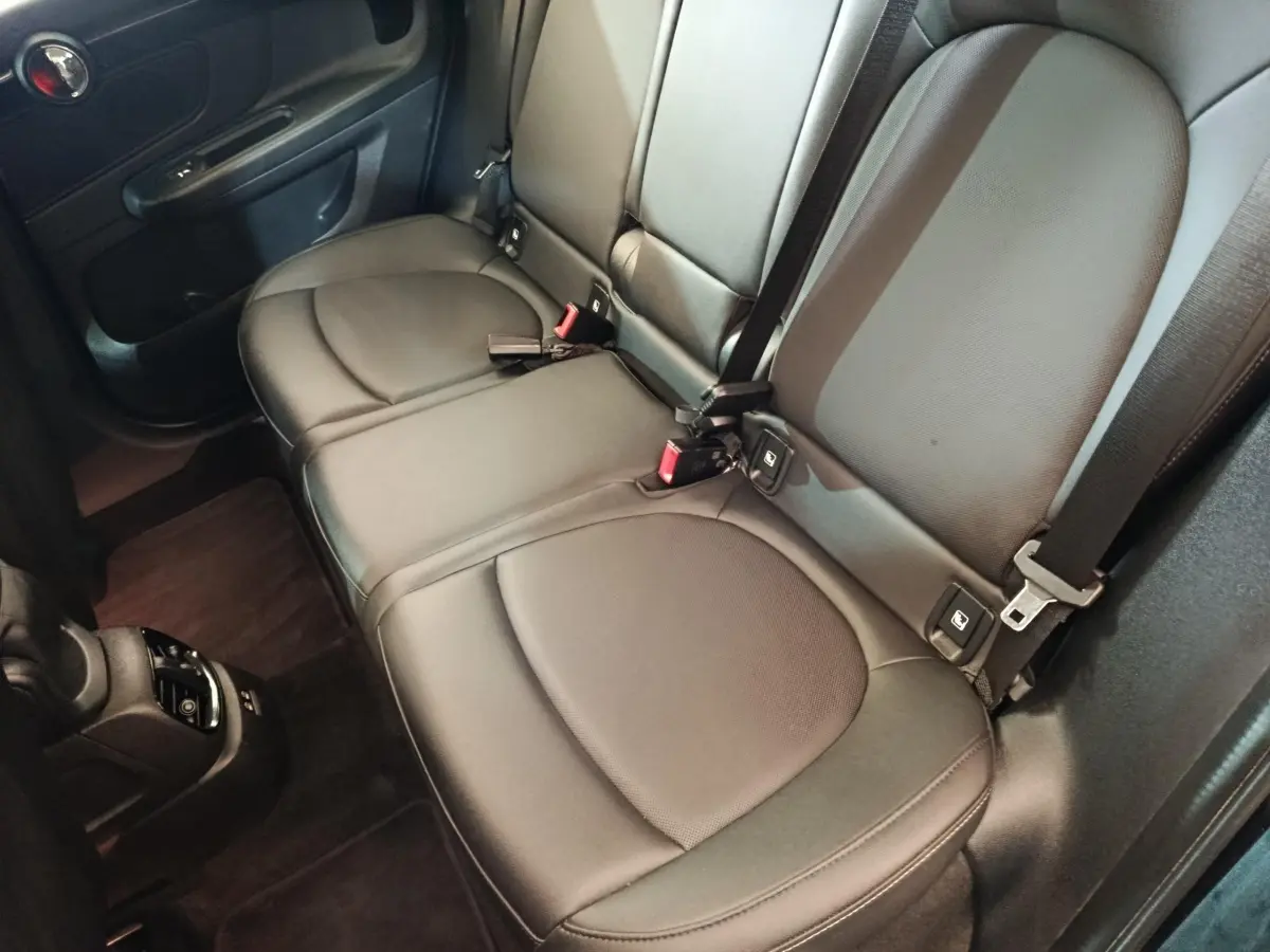 Vue intérieure du siège arrière noir en cuir du MINI COUNTRYMAN Cooper SE 2023, avec ceintures et ancrages Isofix visibles.