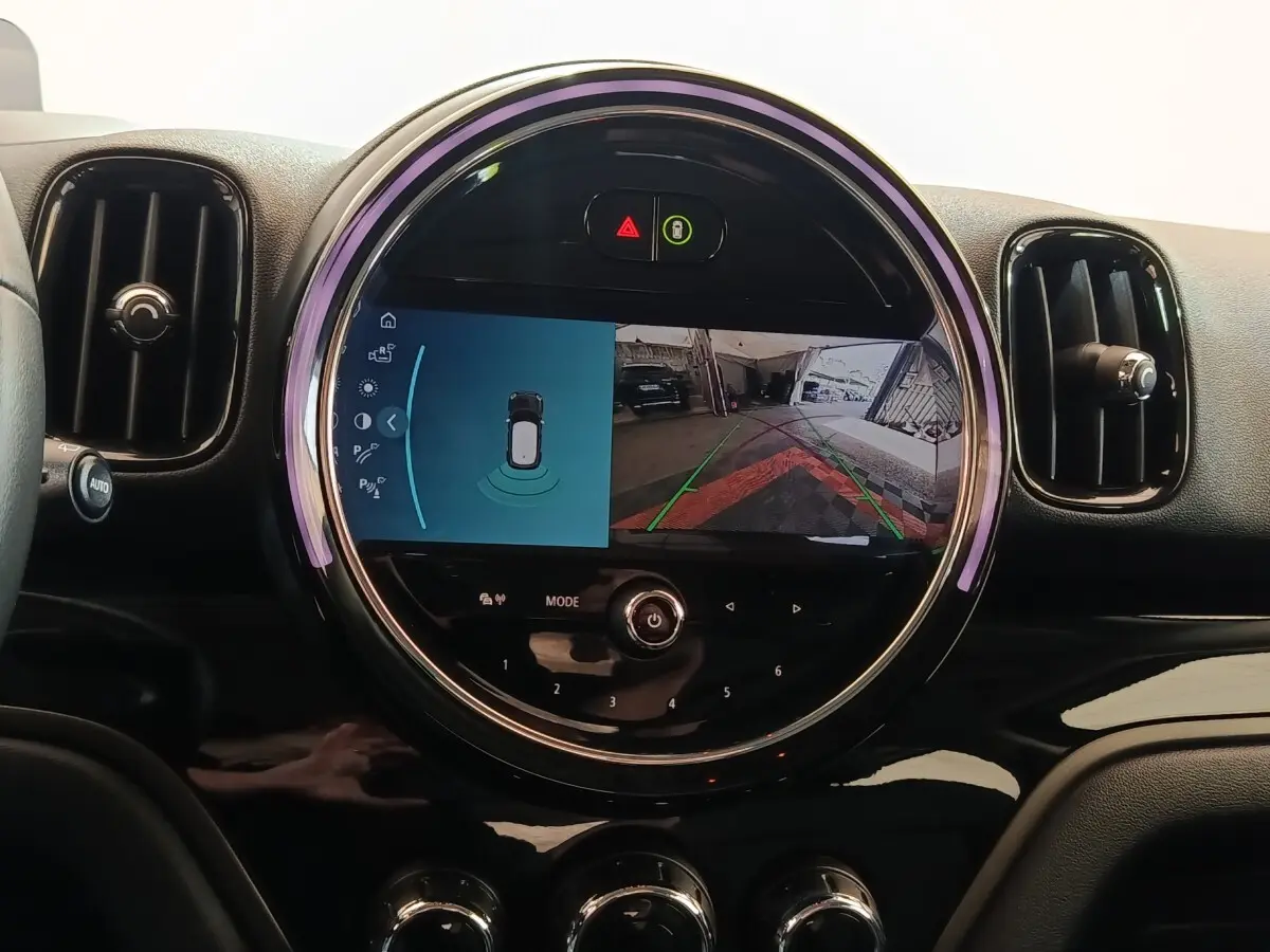 Vue rapprochée du tableau de bord noir du MINI Countryman 2023 avec écran central circulaire affichant la caméra de recul.