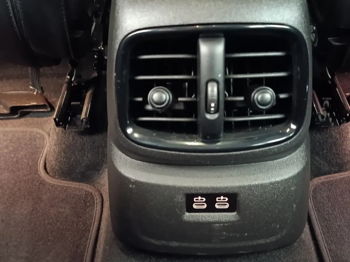 Gros plan sur la console arrière noire du MINI Countryman 2023 avec bouches d’aération et ports USB visibles.