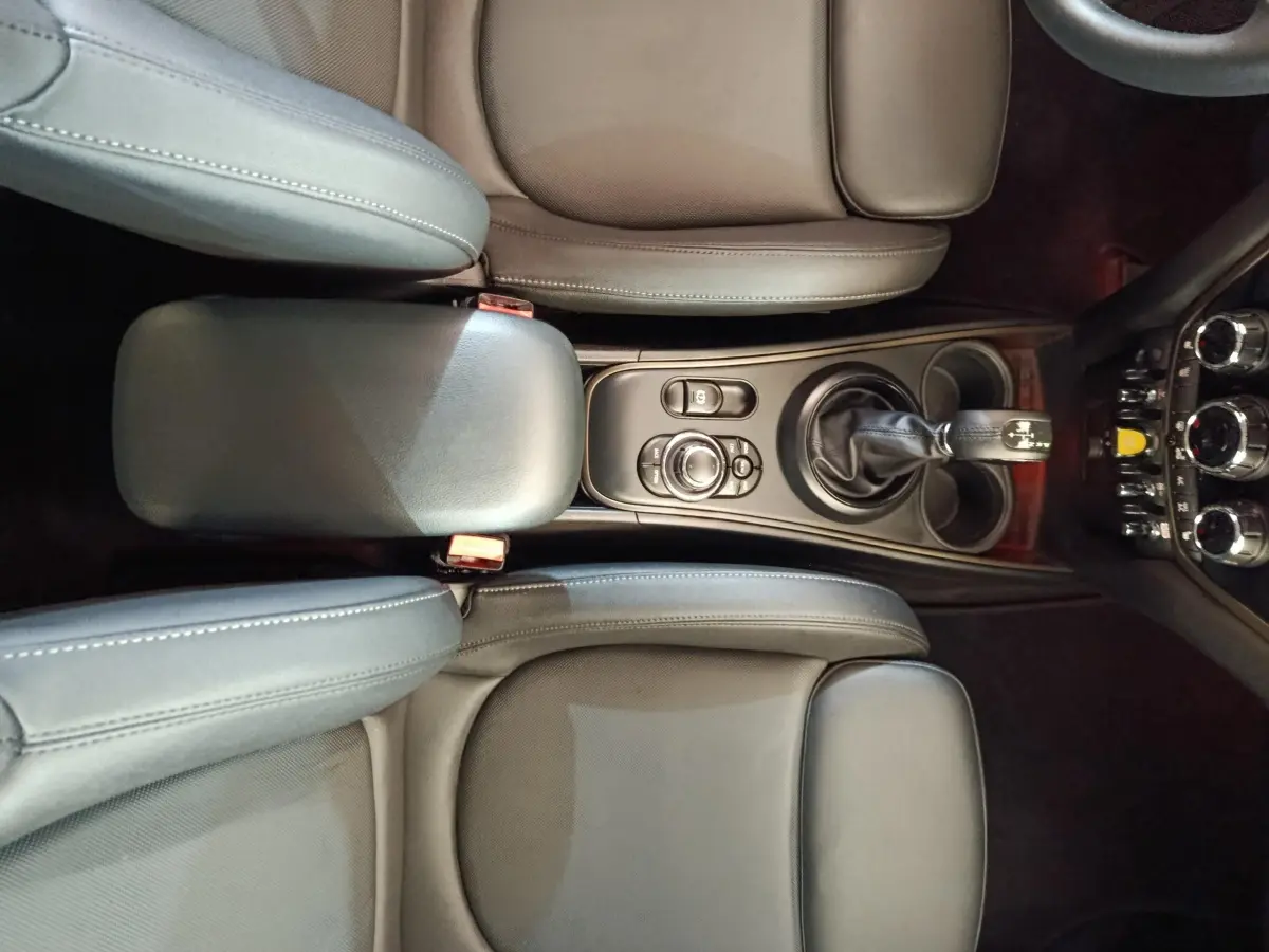 Vue plongeante sur la console centrale et les sièges en cuir noir du MINI Countryman Cooper SE 2023.