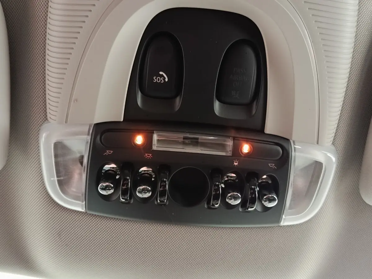 Vue en gros plan du plafonnier intérieur avec interrupteurs et boutons chromés du MINI Countryman noir 2023.