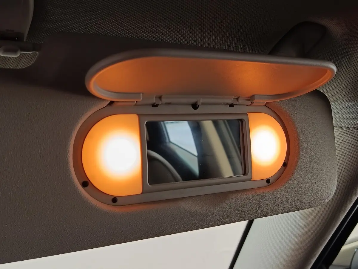 Miroir de courtoisie éclairé sur pare-soleil intérieur du MINI Countryman Cooper SE noir, vue rapprochée côté conducteur.