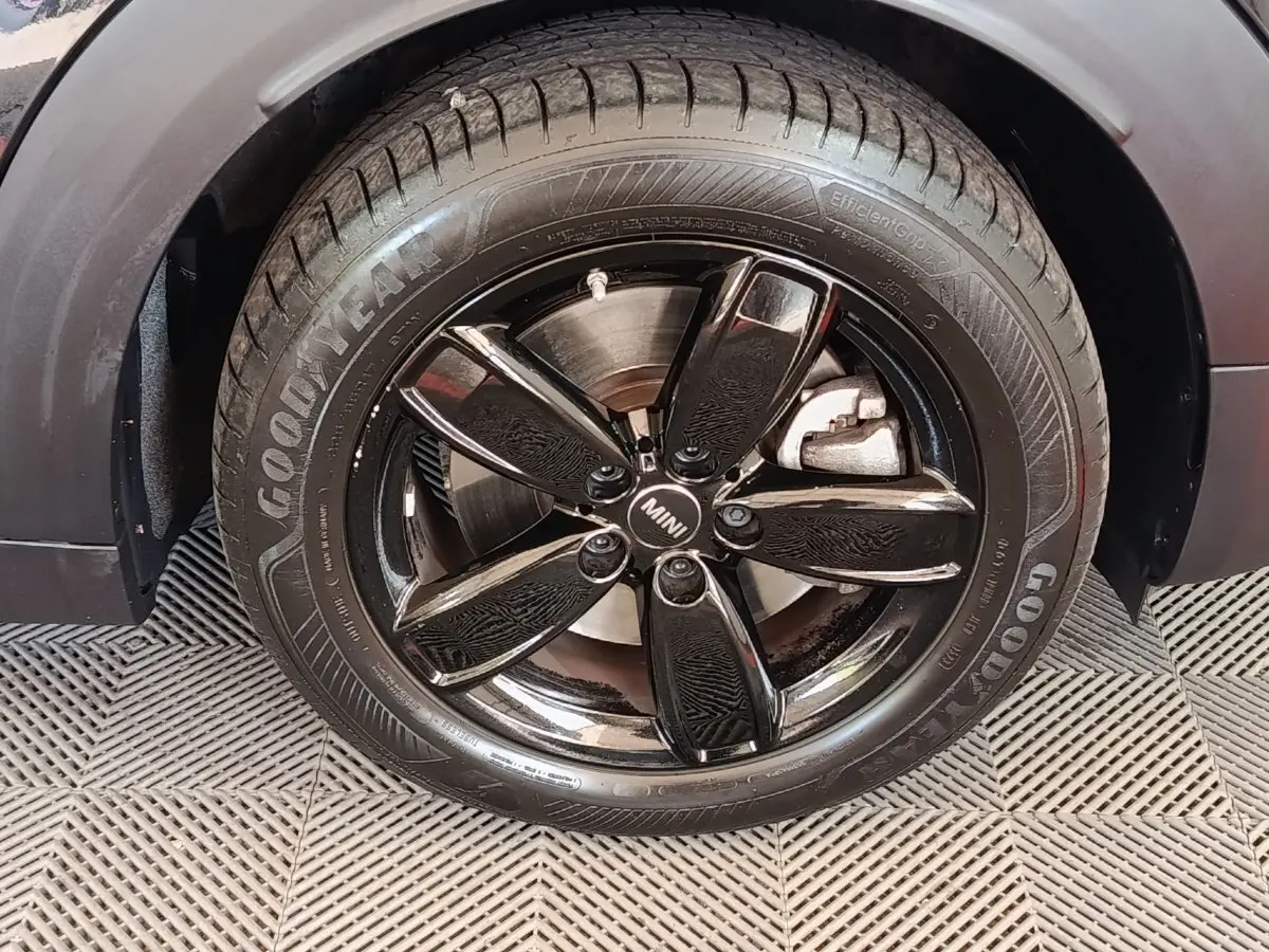 Gros plan sur la roue avant droite noire brillante d’un MINI Countryman Cooper SE 2023 avec pneu Goodyear.