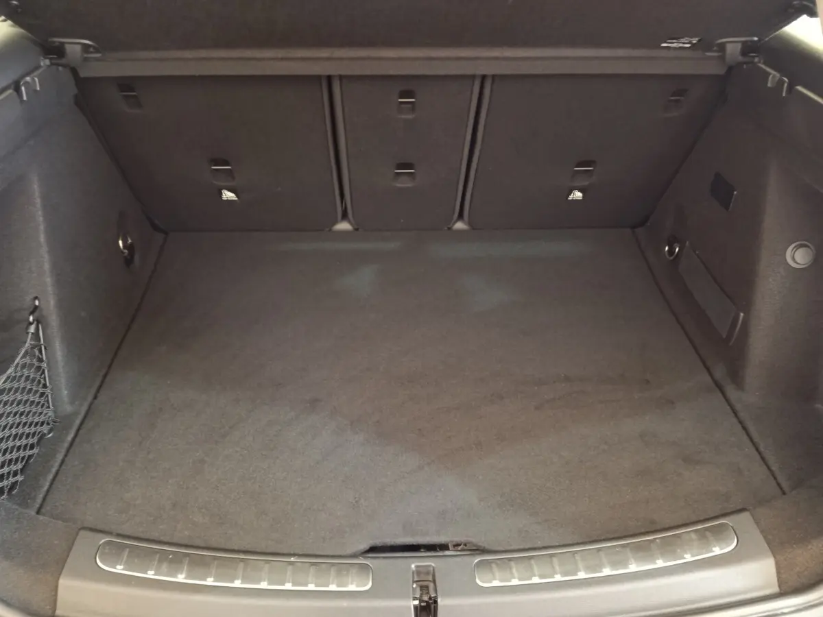 Coffre spacieux vu de face, intérieur noir avec filet de rangement sur le côté gauche, MINI Countryman 2023.