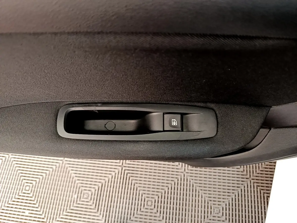 Gros plan sur la commande de lève-vitre côté intérieur d'une Renault Mégane Business E-Tech blanche.
