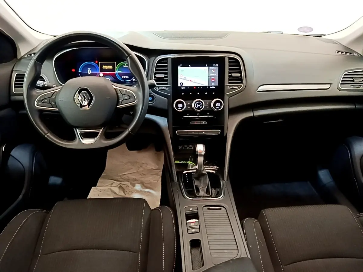 Vue intérieure avant de la Renault Mégane Business E-Tech hybride, tableau de bord avec écran tactile central et volant multifonctions.