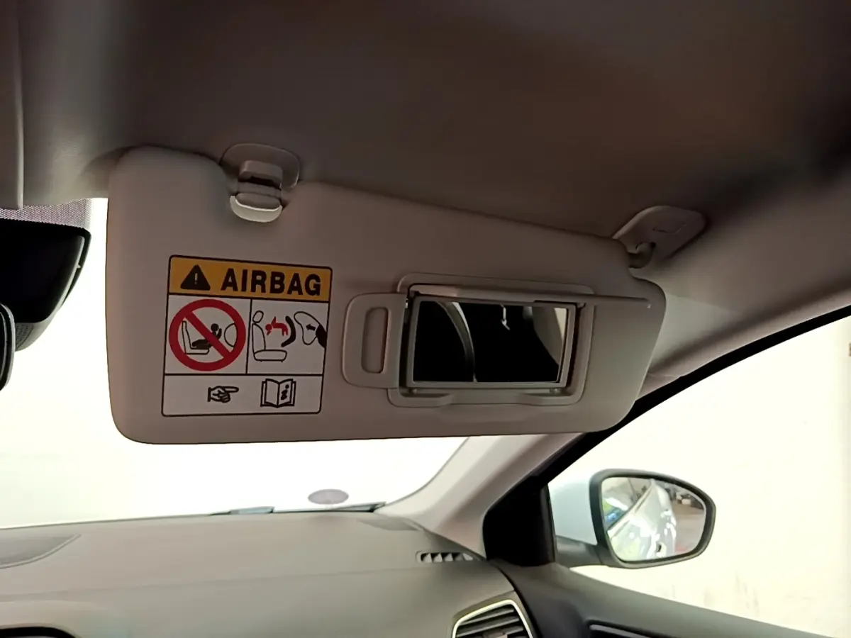 Vue intérieure côté passager de la Renault Mégane Business E-Tech hybride blanche, avec pare-soleil et miroir intégré.
