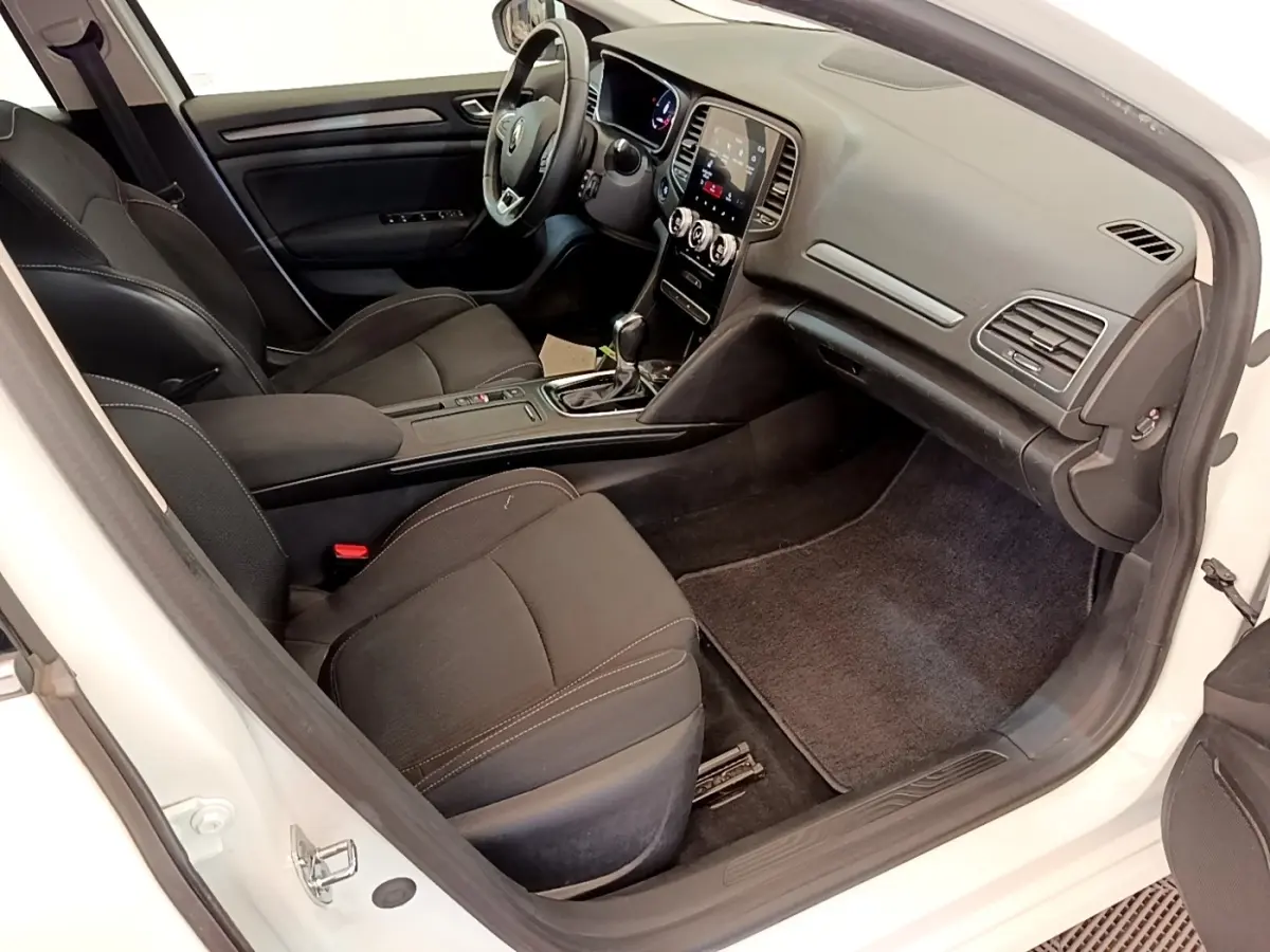 Intérieur côté passager d'une Renault Mégane Business E-Tech blanche, avec tableau de bord digital et sièges noirs.