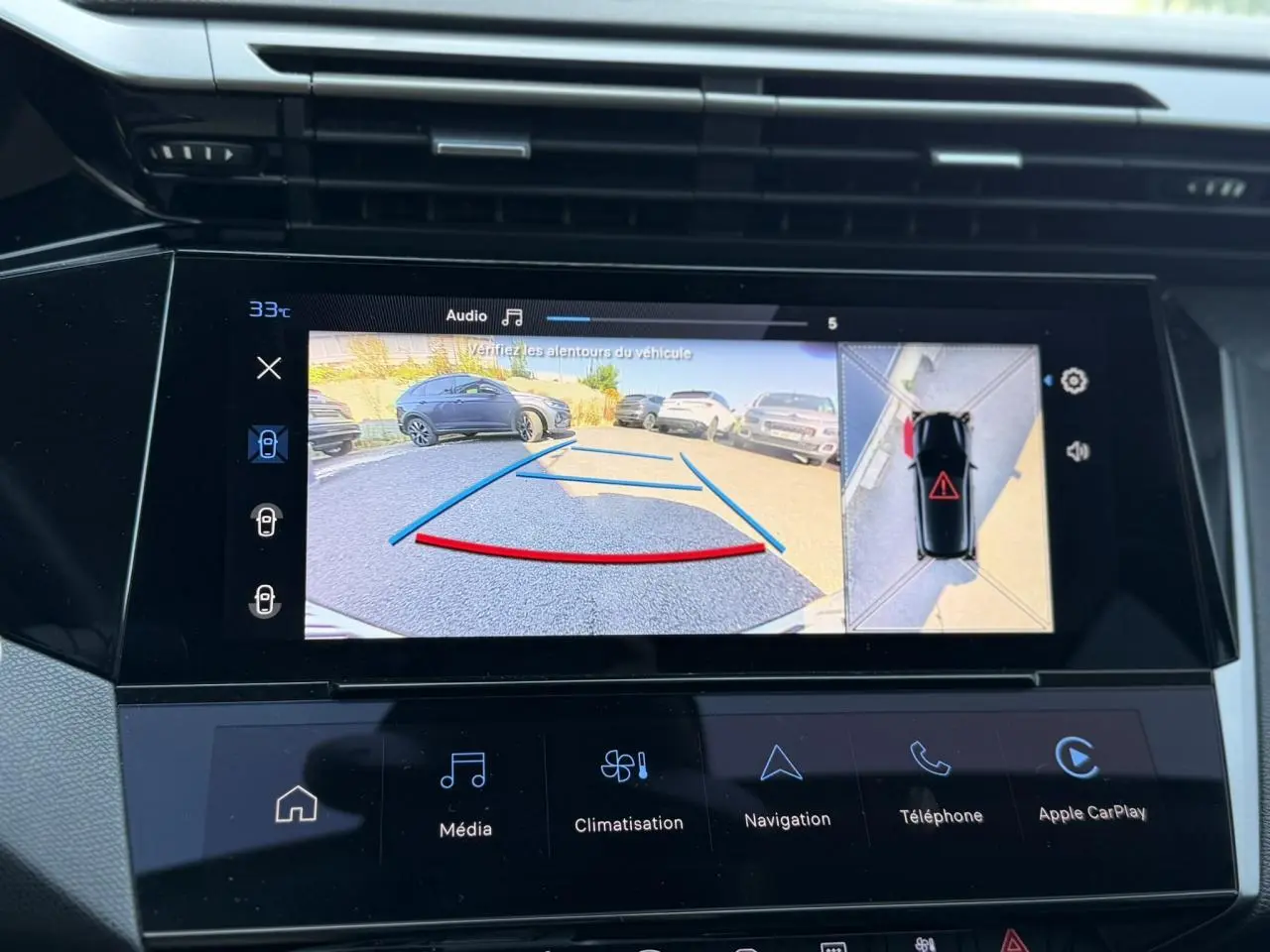 Vue de l'écran tactile intérieur montrant la caméra de recul et l'affichage 360° du Peugeot 308 noir Perla.