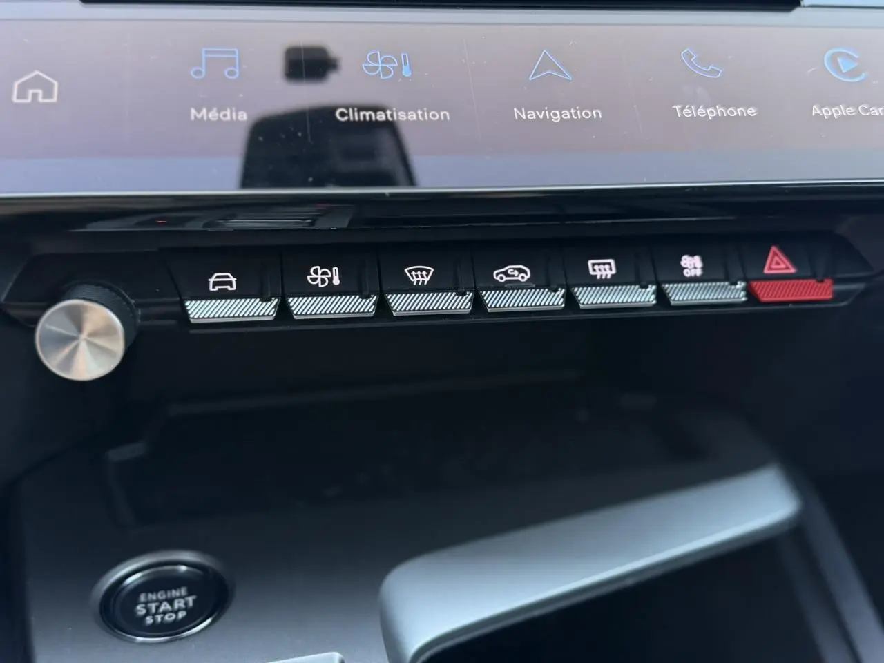 Vue rapprochée du tableau de bord de la Peugeot 308 Hybrid 2025, montrant les commandes de climatisation et démarrage.