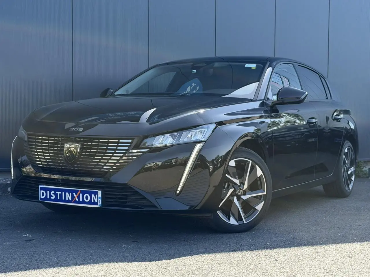 Peugeot 308 Hybrid noir Perla vue 3/4 avant droit, avec calandre distinctive et jantes alliage 17 pouces.