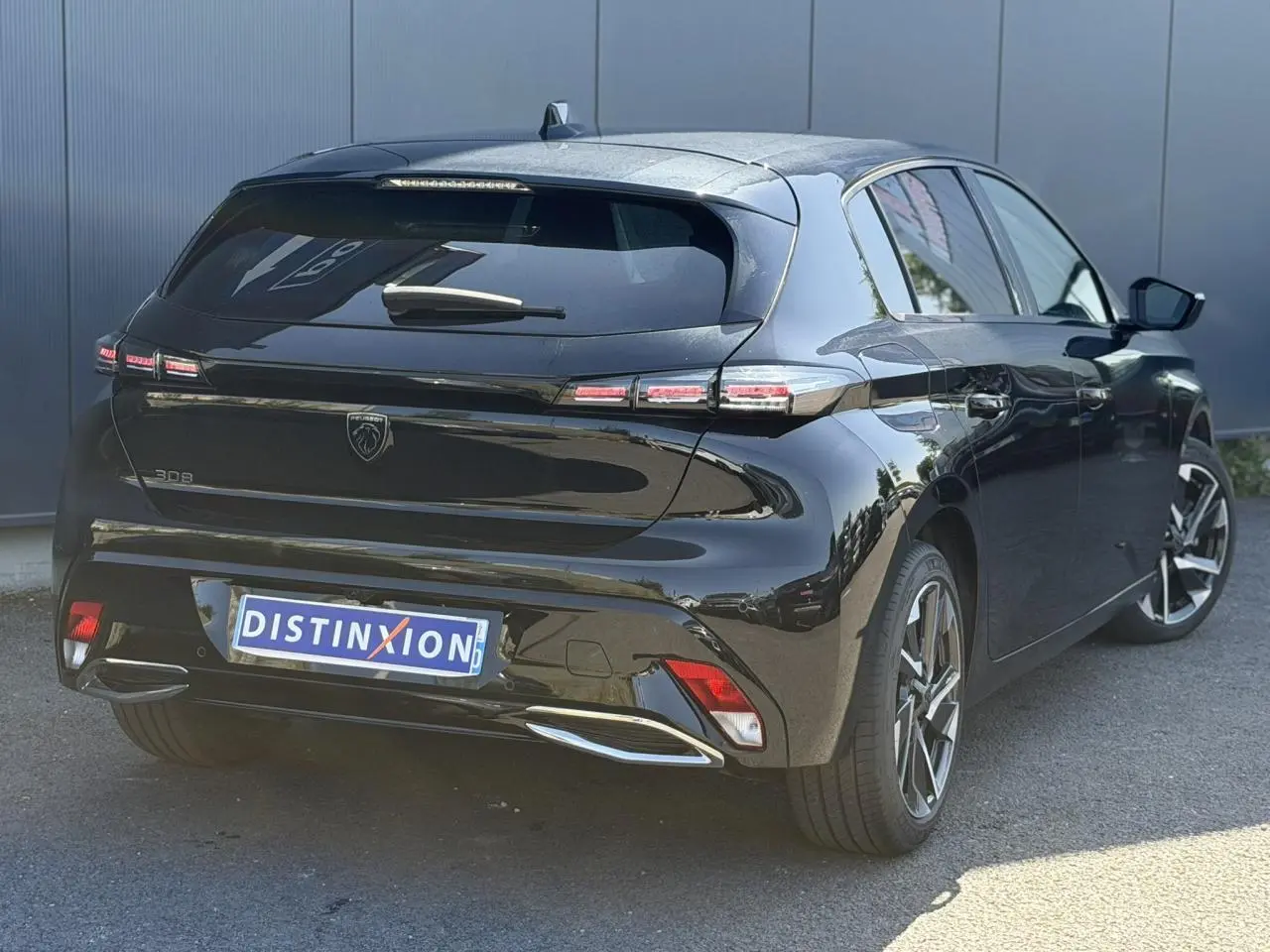 Vue 3/4 arrière droite de la Peugeot 308 Hybrid 145 noire Perla avec feux arrière LED et jantes alliage 17 pouces.
