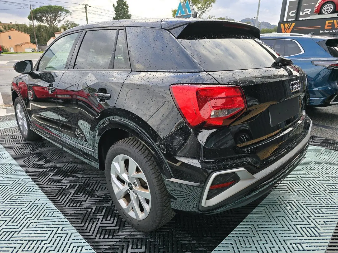 Audi Q2 noir mythic vue 3/4 arrière droit avec vitres surteintées et jantes aluminium 5 branches doubles.