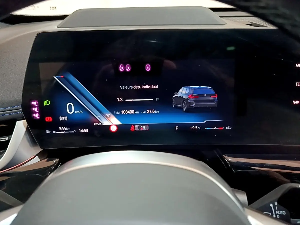 Tableau de bord numérique du BMW X1 noir 2023, affichant vitesse, consommation et image du véhicule en vue avant.
