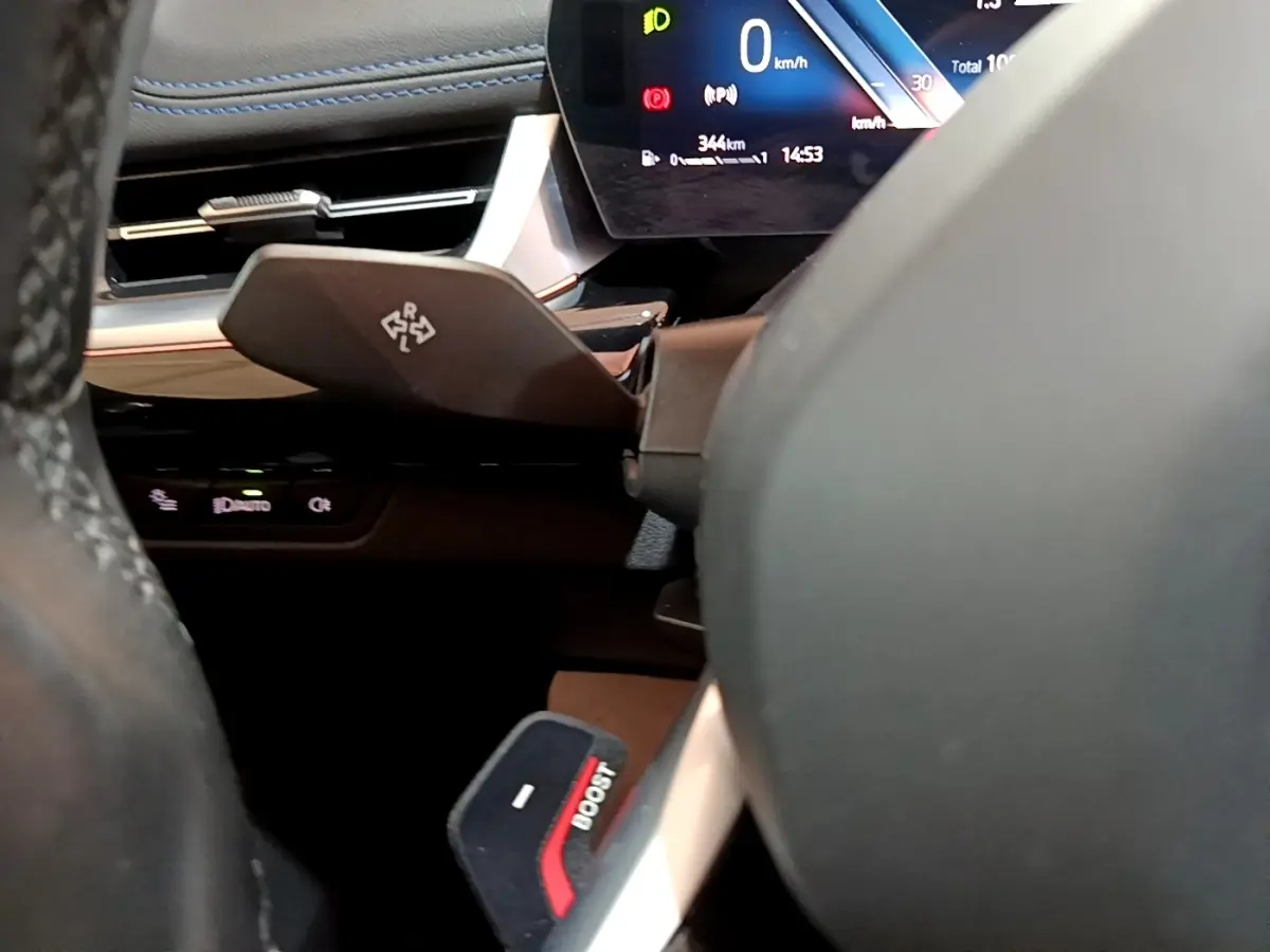 Gros plan sur le volant et le tableau de bord numérique du BMW X1 noir, affichant 0 km/h et indicateurs lumineux.