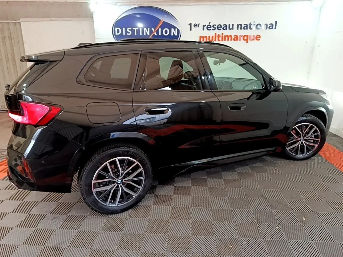 BMW X1 xDrive23i M Sport noir vue de profil côté droit, avec jantes alliage et vitres teintées.
