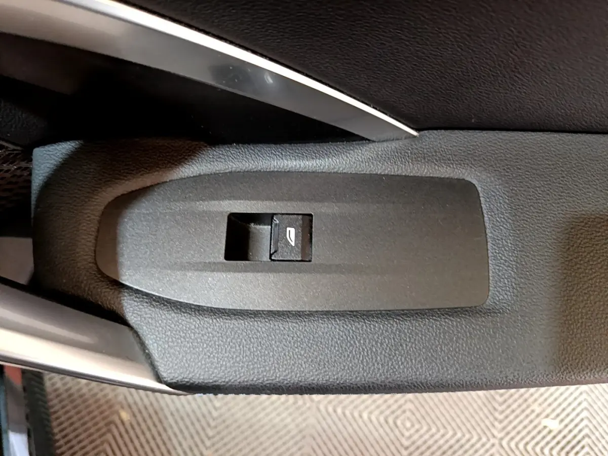 Bouton de commande de vitre électrique sur la porte intérieure noire d'une BMW X1 xDrive23i M Sport 2023.