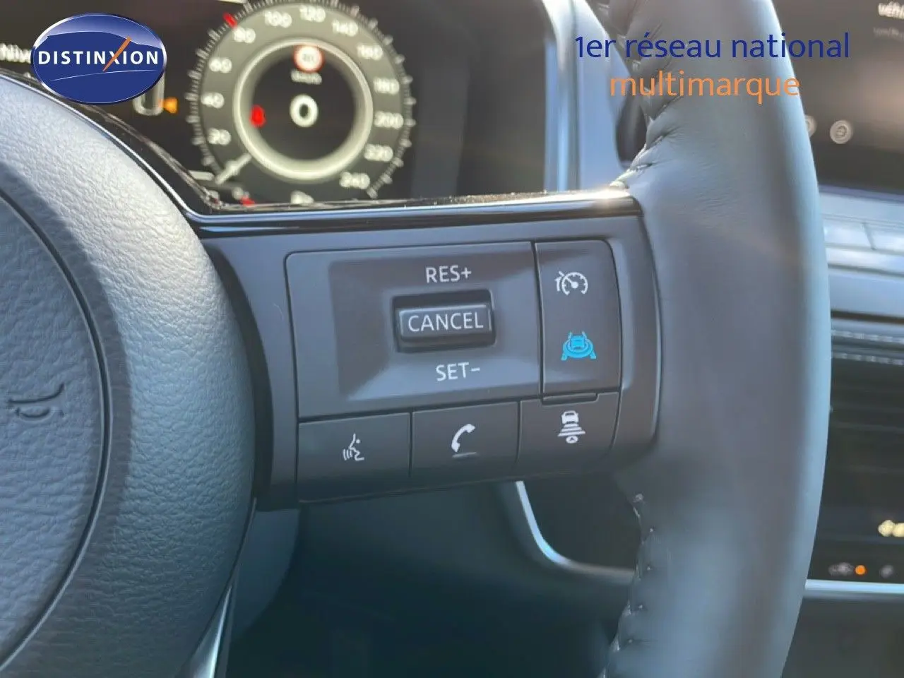 Gros plan sur le volant cuir noir du Nissan Qashqai 2025, avec commandes de régulateur de vitesse et tableau de bord numérique en arrière-plan.