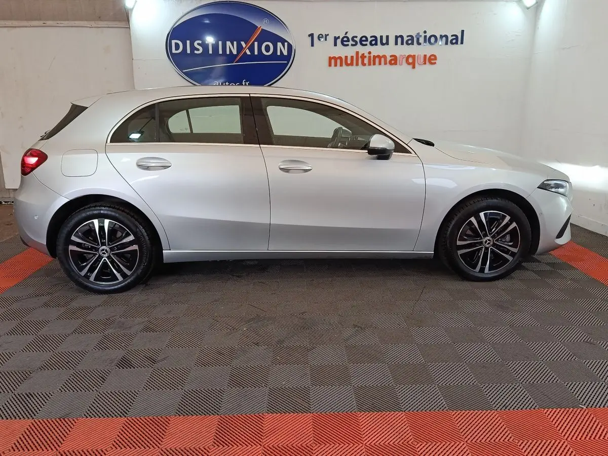 Vue de profil côté gauche d'une Mercedes Classe A 250 e Business Line gris clair avec jantes alliage noires.