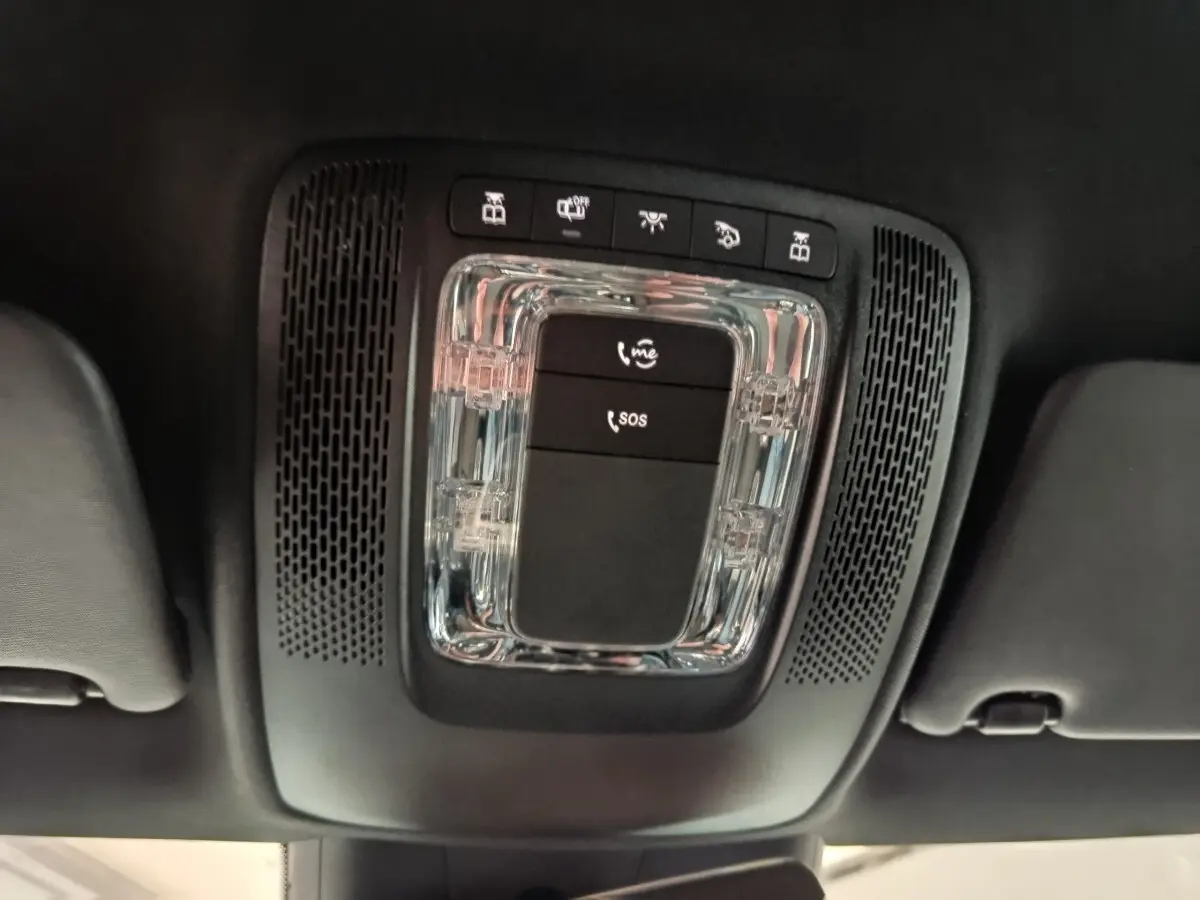 Vue en contre-plongée du plafonnier noir avec commandes SOS et appels du Mercedes Classe A gris clair 2023.