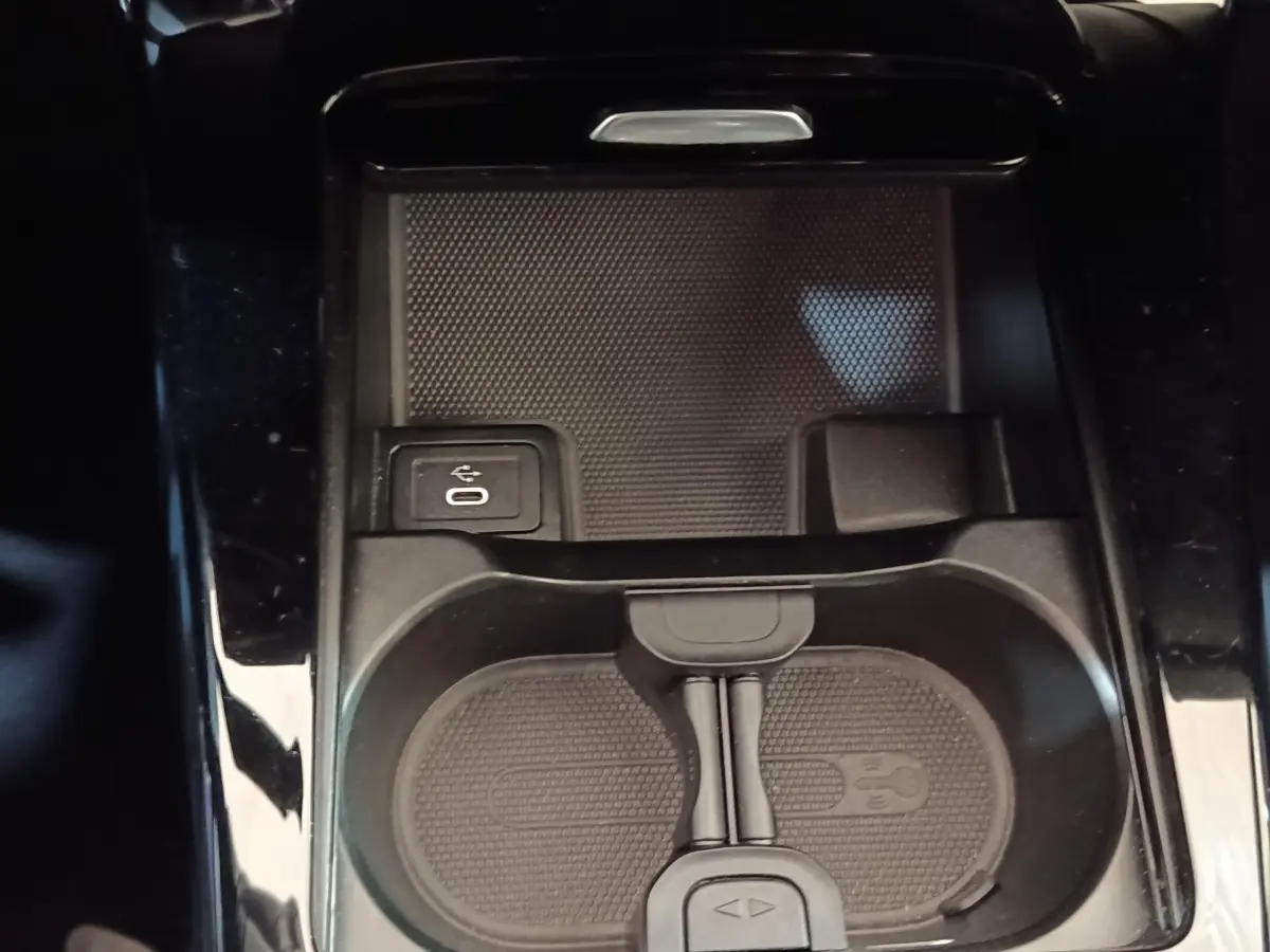 Gros plan sur la console centrale noire de la Mercedes Classe A 250 e avec prise USB et espace de rangement.